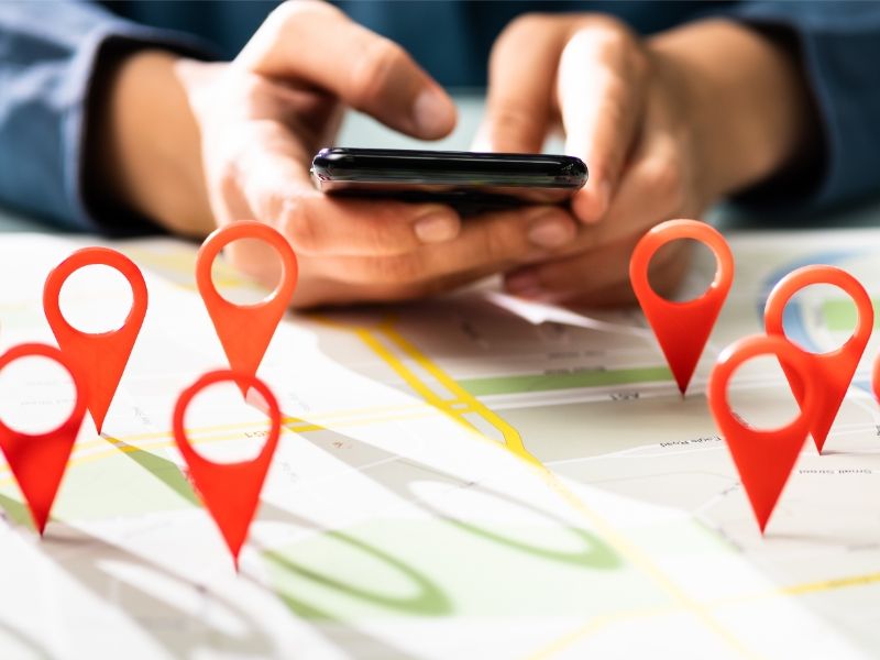 Repère sur une carte avec mains tenant un téléphone